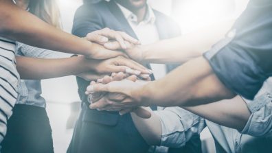 Students hold their hands together in a circle